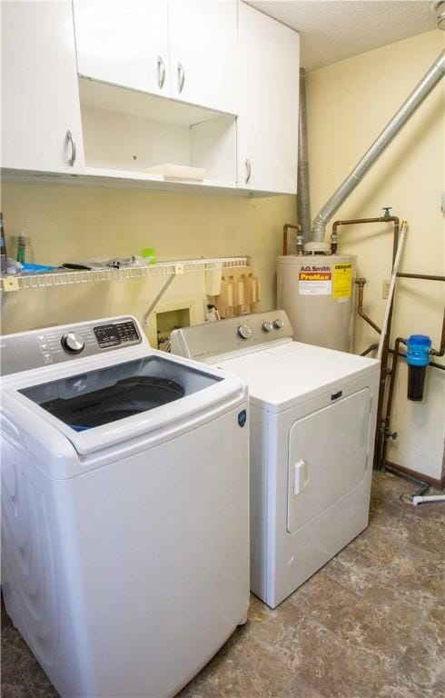 1021 Sunset Rdg, Danville, IL 61832 - laundry area with washer and clothes dryer, water heater, cabinet space, and stone finish floors