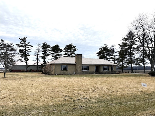 view of front of home featuring a chimney and a front yard