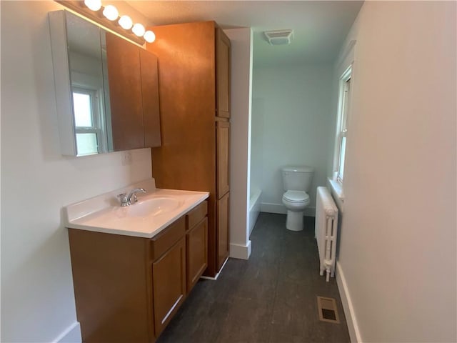 101 S Sheridan St, Pana, IL 62557 - bathroom featuring radiator, baseboards, toilet, vanity, and a bathtub