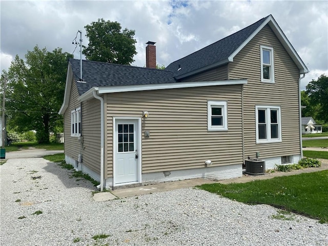101 S Sheridan St, Pana, IL 62557 - rear view of property featuring central air condition unit, a chimney, and roof with shingles