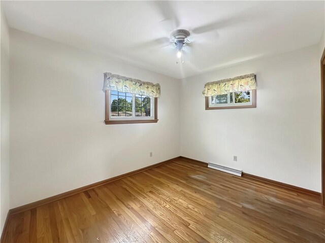723 Kenton Dr, Charleston, IL 61920 - unfurnished room featuring plenty of natural light, light wood-style floors, ceiling fan, and baseboard heating