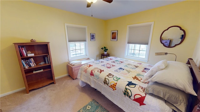 carpeted bedroom with multiple windows, a ceiling fan, and baseboards