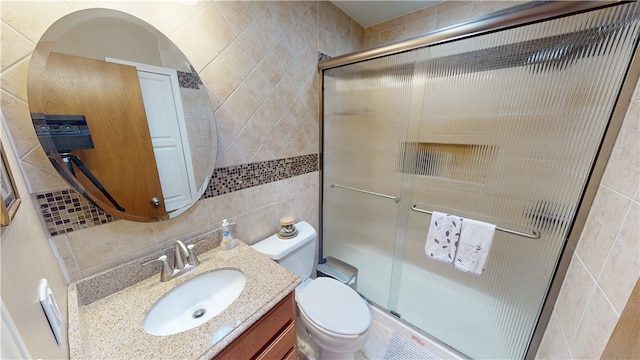 bathroom featuring tasteful backsplash, a shower stall, tile walls, and vanity