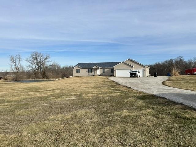 single story home with a garage and a front lawn