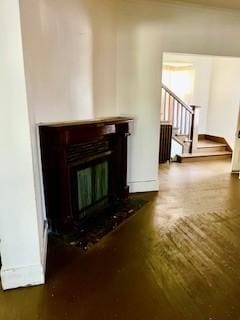 702 Chandler St, Danville, IL 61832 - unfurnished living room featuring a glass covered fireplace, stairs, and wood finished floors