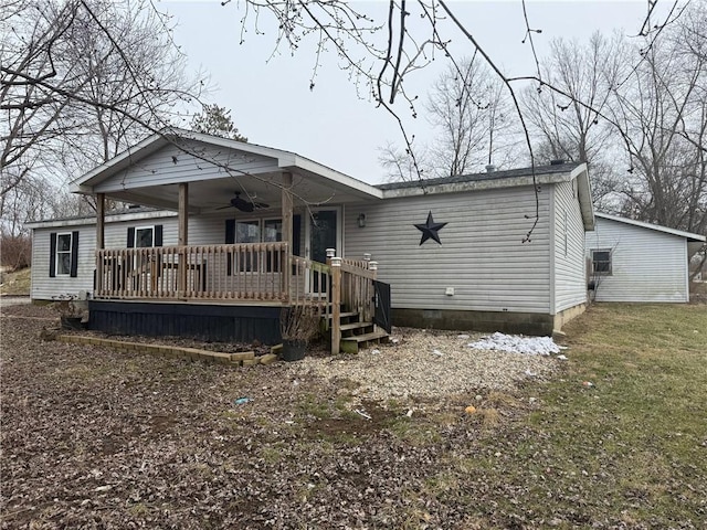 view of front of house featuring ceiling fan, a deck, and a front yard