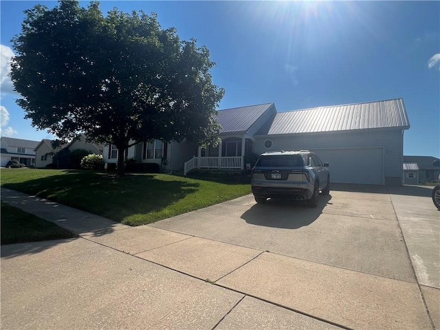 1215 Westside Dr, Mt Zion, IL 62549 - view of front facade with concrete driveway, a garage, a front yard, a metal roof, and a porch