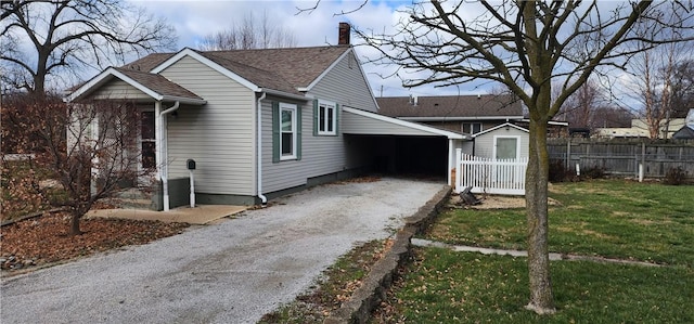 view of front of home with a front yard and a carport