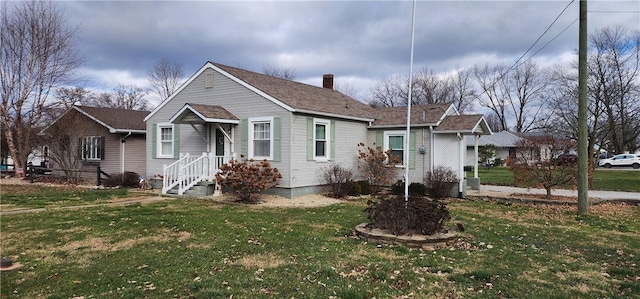 bungalow-style home with a front yard