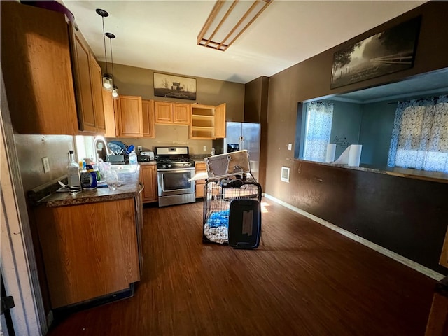 kitchen featuring appliances with stainless steel finishes, dark hardwood / wood-style flooring, pendant lighting, and sink