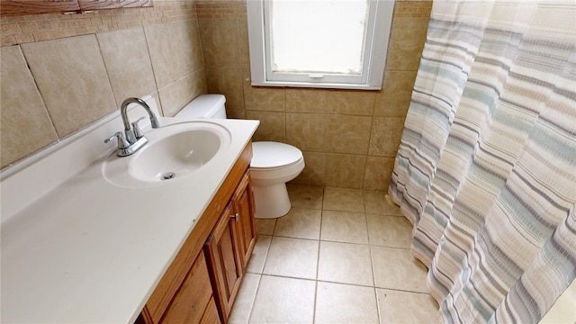 bathroom with a shower with curtain, tile patterned floors, toilet, vanity, and tile walls