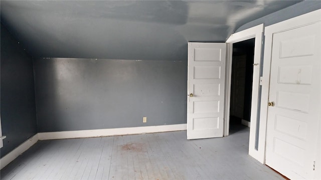 bonus room with light hardwood / wood-style floors and vaulted ceiling