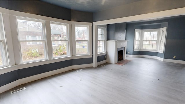 unfurnished living room featuring hardwood / wood-style flooring and a healthy amount of sunlight