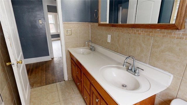 bathroom with tile patterned flooring, vanity, and tile walls