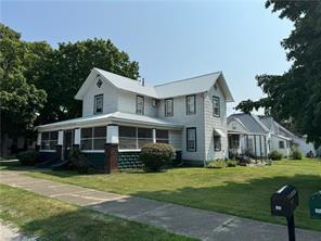 view of front of home featuring a sunroom and a front lawn