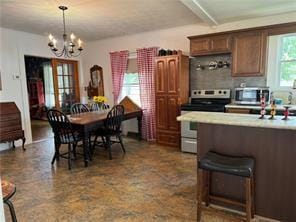 kitchen featuring an inviting chandelier, appliances with stainless steel finishes, a breakfast bar, and hanging light fixtures