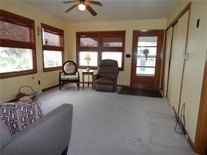 carpeted living room with ceiling fan