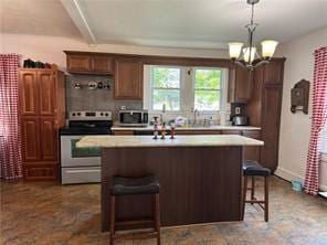 kitchen featuring a center island, a kitchen breakfast bar, pendant lighting, stainless steel appliances, and range hood