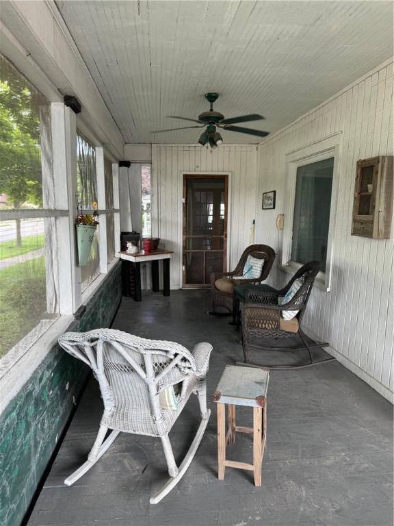 sunroom / solarium featuring a healthy amount of sunlight and ceiling fan