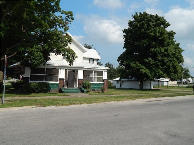 view of front of property featuring a front lawn and a sunroom