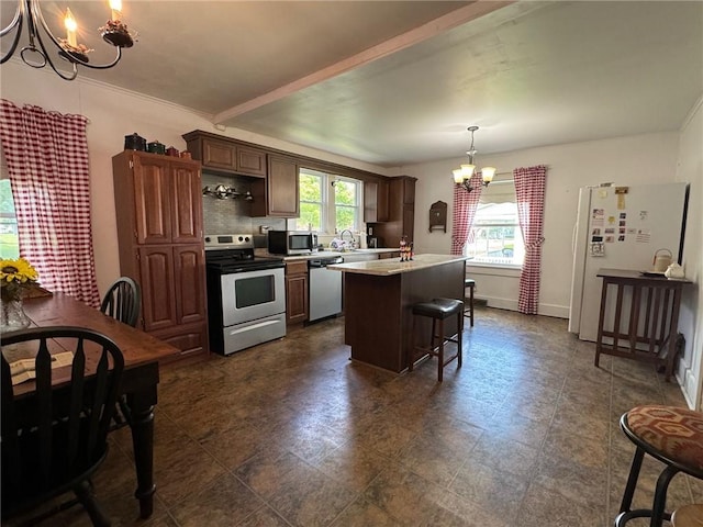 kitchen with a chandelier, a kitchen breakfast bar, a kitchen island, pendant lighting, and stainless steel appliances