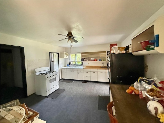 bedroom featuring dark carpet, a sink, a ceiling fan, and freestanding refrigerator