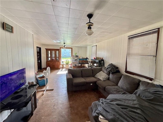 living room with wood walls and concrete floors
