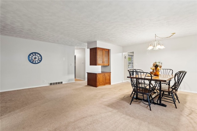 317 Holiday Dr, Decatur, IL 62526 - dining space featuring baseboards, light carpet, a textured ceiling, and a chandelier