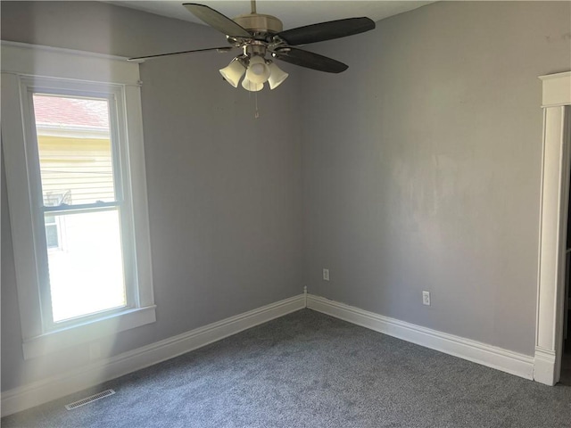 1005 Edgar Ave, Mattoon, IL 61938 - unfurnished room featuring dark colored carpet, a ceiling fan, and healthy amount of natural light