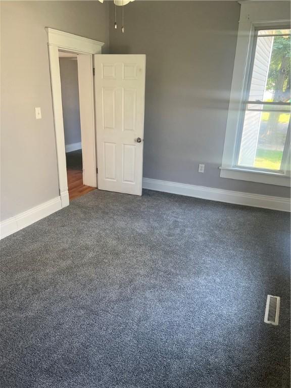 1005 Edgar Ave, Mattoon, IL 61938 - unfurnished room featuring baseboards and dark colored carpet