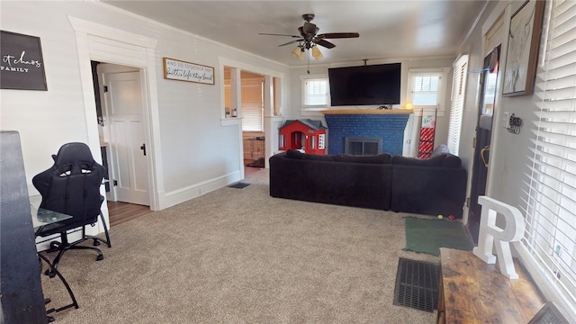 carpeted living room featuring ceiling fan, ornamental molding, and a fireplace