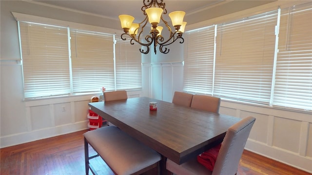 dining room featuring crown molding, dark wood-type flooring, and an inviting chandelier