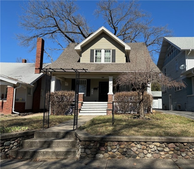 bungalow featuring a porch and a front lawn