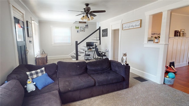 living room featuring ceiling fan, ornamental molding, and carpet floors