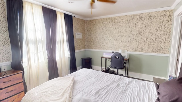 bedroom featuring ceiling fan, crown molding, and multiple windows