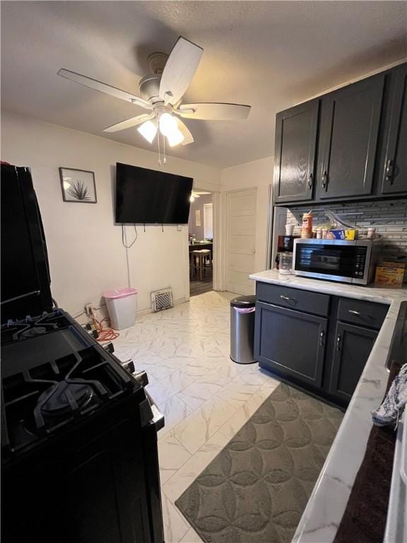 625 S Jackson St, Decatur, IL 62521 - kitchen featuring light countertops, marble finish floor, stainless steel microwave, and ceiling fan