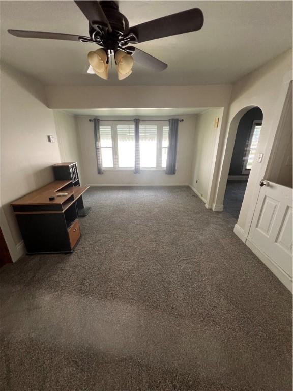 314 W Maple St, Hoopeston, IL 60942 - unfurnished living room with arched walkways, ceiling fan, and carpet floors