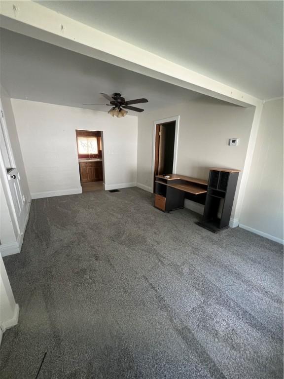 314 W Maple St, Hoopeston, IL 60942 - unfurnished living room with dark colored carpet and ceiling fan