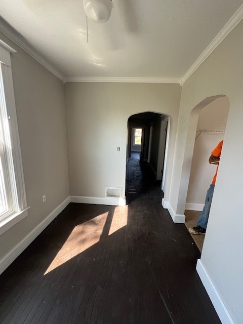 spare room with dark hardwood / wood-style flooring and crown molding