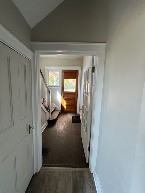 hallway featuring dark wood-type flooring and vaulted ceiling