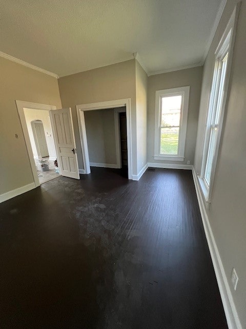 unfurnished living room featuring a textured ceiling, crown molding, and dark hardwood / wood-style floors