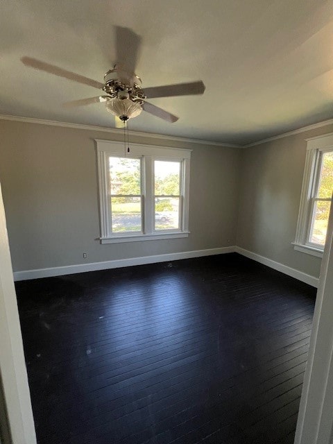 empty room with a wealth of natural light, ceiling fan, dark hardwood / wood-style floors, and ornamental molding