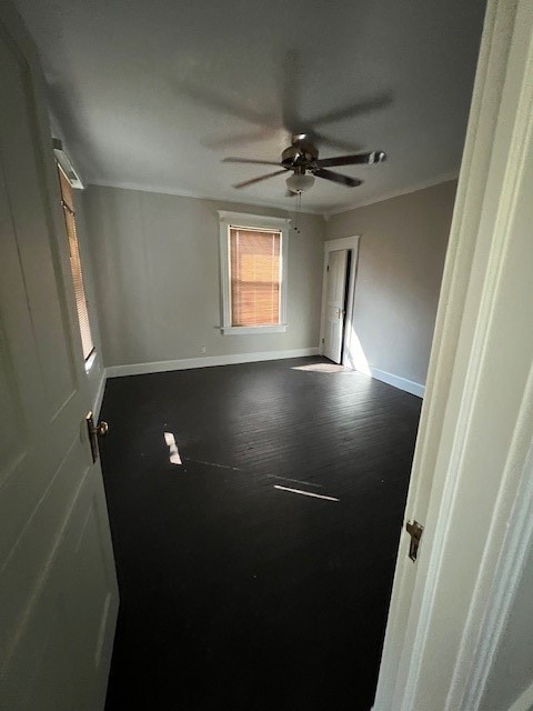 unfurnished room with ceiling fan and crown molding