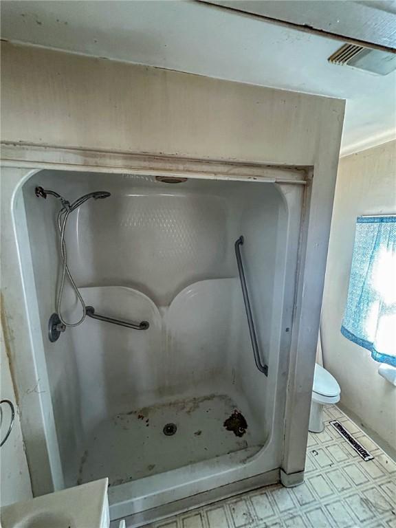 bathroom with toilet, tile patterned floors, walk in shower, and visible vents