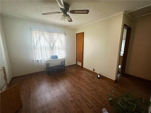 empty room with a ceiling fan, ornamental molding, dark wood-type flooring, and visible vents