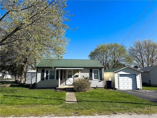 view of front of home with metal roof, a front lawn, and aphalt driveway
