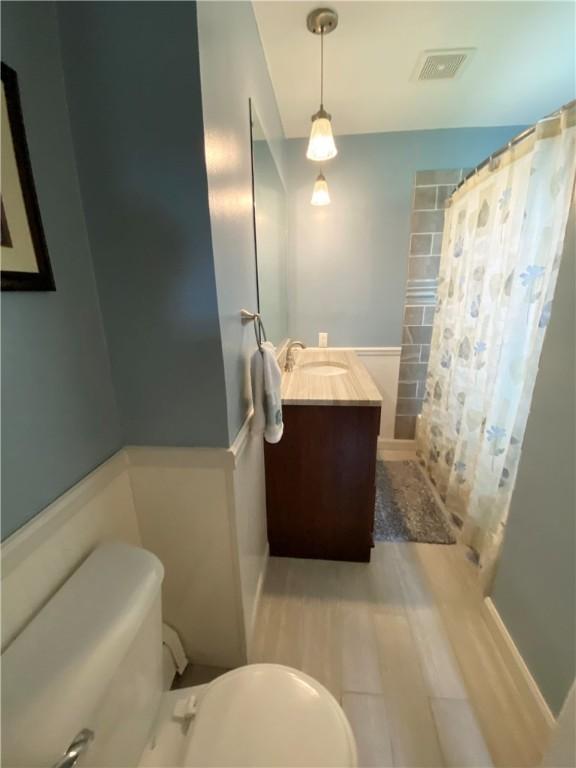 full bath featuring wood finished floors, visible vents, toilet, vanity, and a shower with curtain