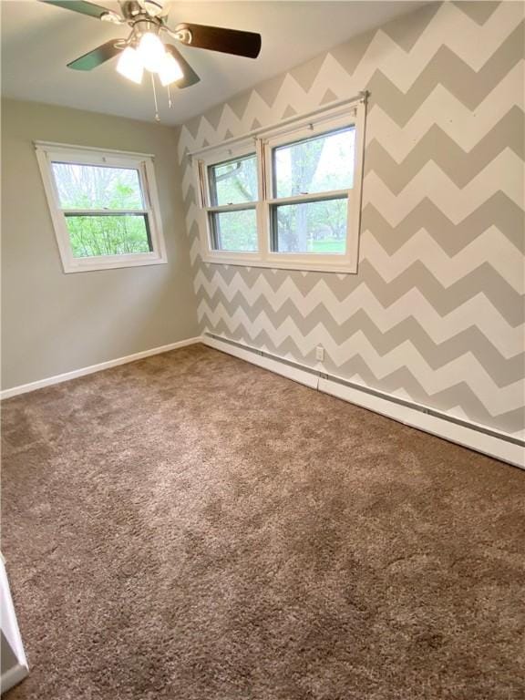 carpeted empty room with a ceiling fan and baseboards