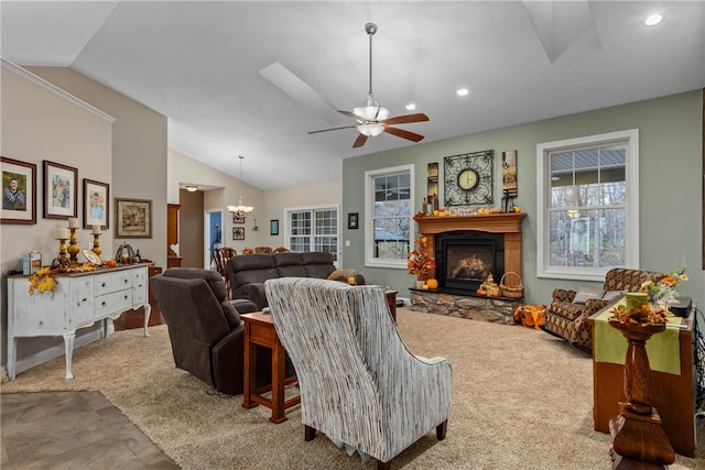 living room featuring carpet, ceiling fan with notable chandelier, a fireplace, and vaulted ceiling