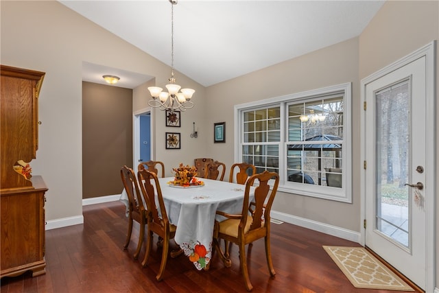 dining space with plenty of natural light, dark hardwood / wood-style floors, vaulted ceiling, and a notable chandelier